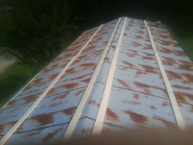 Rusted metal roof panels with new wood purlins before replacement — Storm Damage Roof Repair in Mancelona by Roofing Brothers